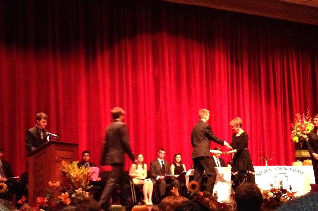 Inductees walk across the stage to receive formal recognition of their new NHS member status.
