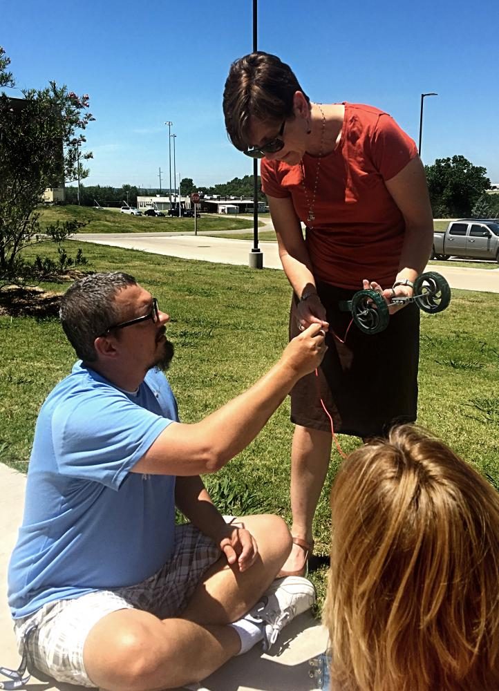 Stohlmann demonstrates the construction of a miniature solar powered car to a group of engineering students.