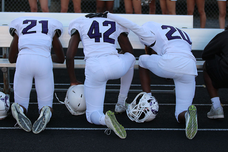 Freshman J. Michael Sturdivant (21), junior Brandon Cooper (42) and senior Terrel Hunter (20) kneel during the national anthem. The three players were joined by inactive senior running back Chris Thomas in their peaceful protest. 