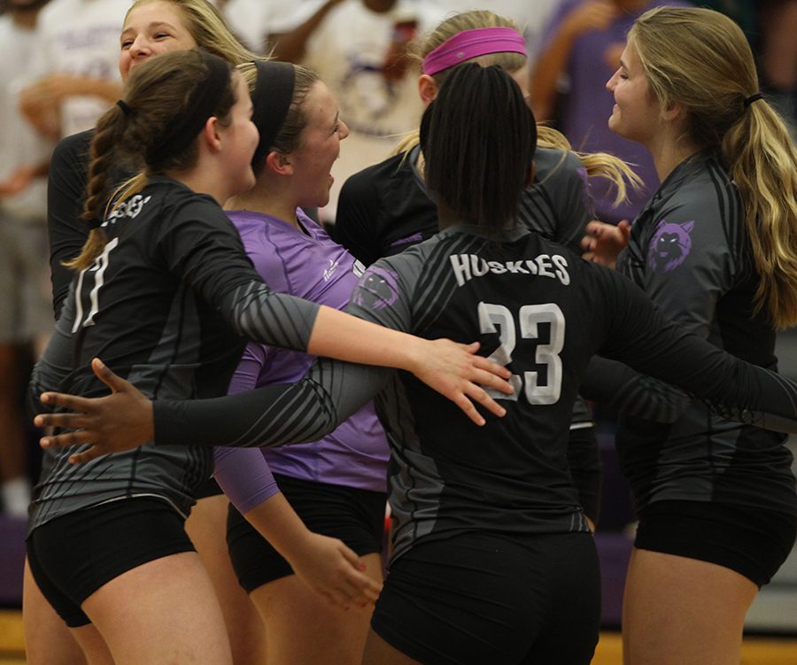 The team celebrates after senior Anna Chalupa (15) scored a point against Shawnee Mission West High School at BVNW Oct. 16.