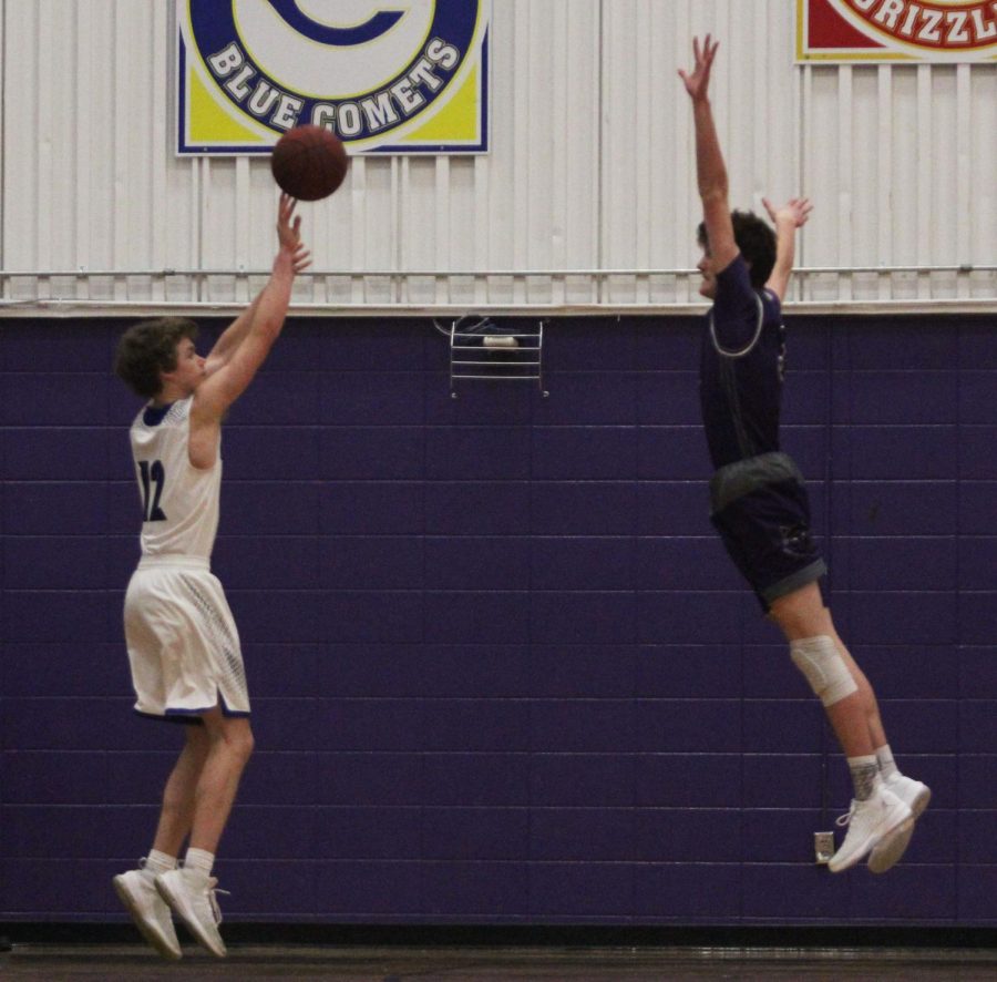 Blue Valley Northwest freshman guard Jack Chapman (3, pictured right) leaps to attempt to alter a 3-point attempt for the Ravens during the second half of the Huskies matchup with the Ravens at Pittsburg High Jan. 19. The Huskies defeated the Ravens, 52-38.