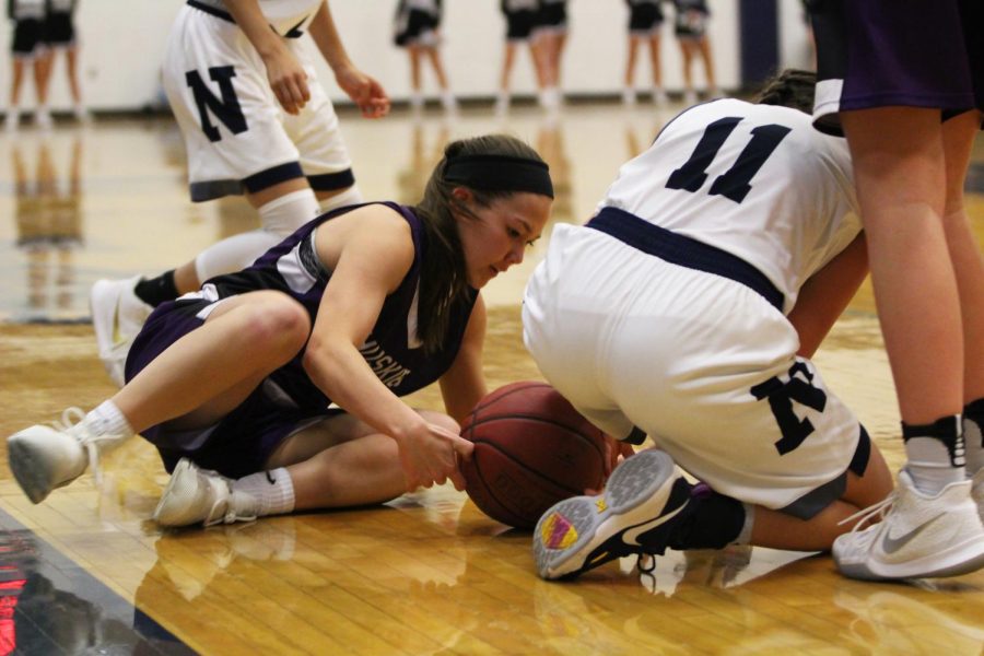 Blue Valley Northwest junior guard Haley Shin (11) dives on the floor to fight for a loose ball in the Huskies matchup with Blue Valley North at BVN Jan. 12. 