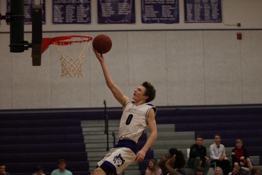 Blue Valley Northwest junior guard Christian Braun (0) goes up for a finger roll layup in the third quarter of the Huskies matchup with East at BVNW Jan. 30. The Huskies defeated the Bears, 87-28.