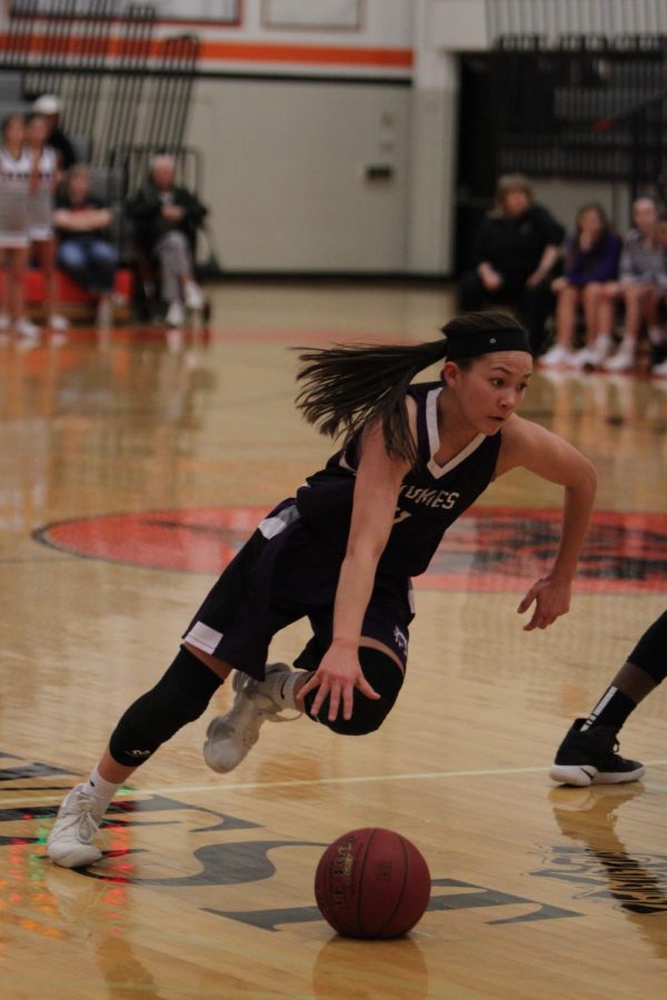 Blue Valley Northwest junior guard Haley Shin (11) dribbles the ball during the first half of the Huskies substate matchup with Shawnee Mission Northwest at SMNW Feb. 27. The Huskies were defeated by the Cougars, 43-34.