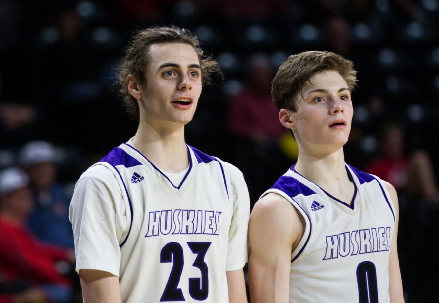 BVNW alumni Parker Braun (23) and Christian Braun (0) watch the action from the bench after checking out in the fourth quarter of the Huskies matchup against Lawrence High at Charles Koch Arena March 8. The Huskies defeated the Lions, 65-37. 