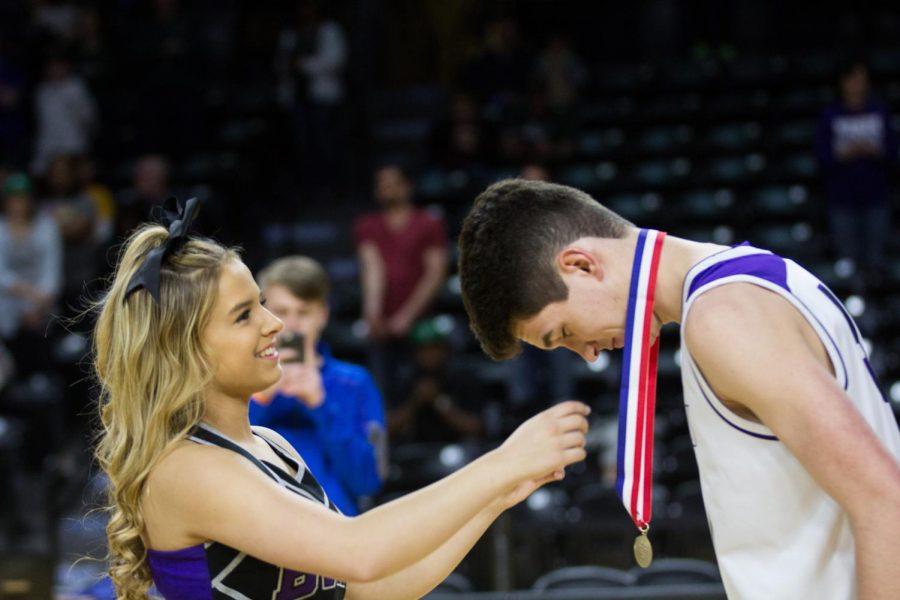 Blue Valley Northwest junior forward Matt Chapman (50) receives his first place medal after the Huskies matchup with Lawrence Free State March 10 at Charles Koch Arena. The Huskies defeated the Firebirds, 51-40. 