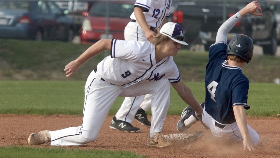Senior Drew Black tags out a BVN baserunner attempting to steal second base during the top of the fifth inning of the Huskies matchup with Blue Valley North April 26. The Huskies defeated the Mustangs, 12-3. 