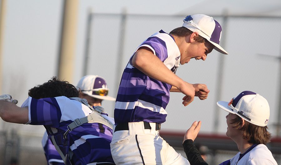 Sophomore shortstop Ryan Callahan celebrates the victory over Blue Valley Southwest with senior catcher Clayton Leathers April 5 at the DAC. The Huskies defeated the Timberwolves, 6-4. 