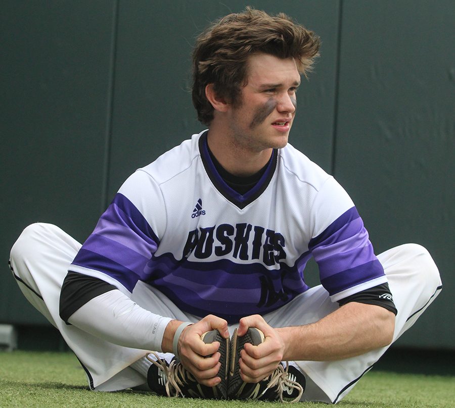 Senior Clayton Leathers stretches prior to the Huskies matchup with Summit Christian Academy at Kauffman Stadium April 21. The Huskies defeated the Eagles, 6-2. 