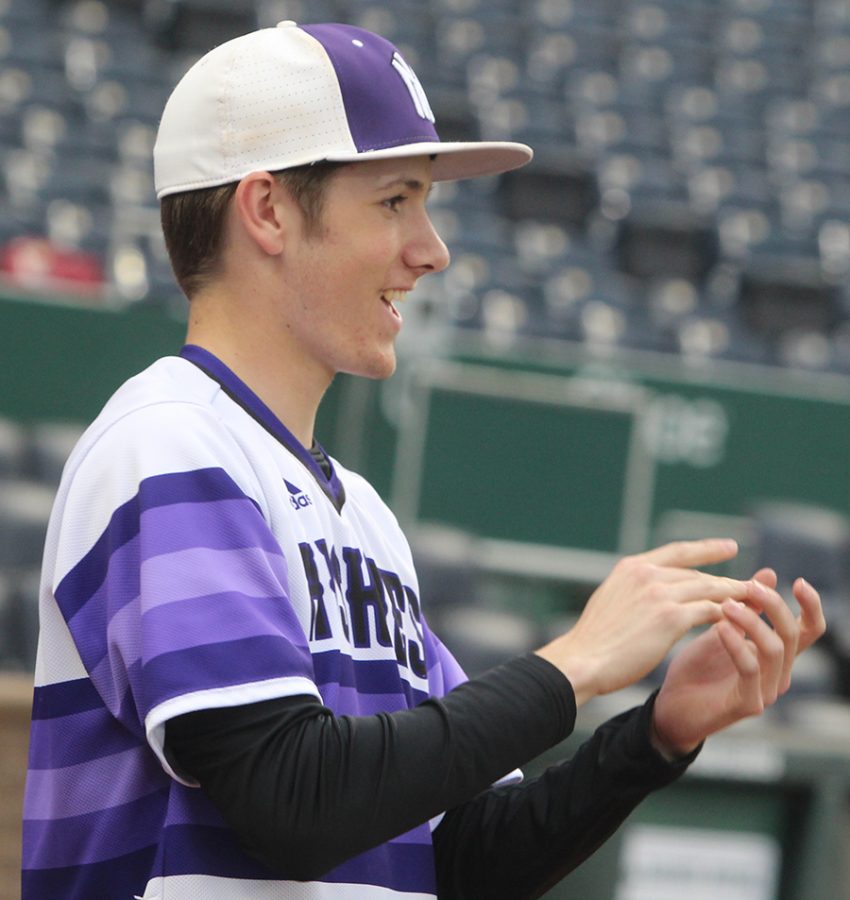 Sophomore Matt Miller claps in support of a teammate during the Huskies matchup with Summit Christian Academy at Kauffman Stadium April 21. The Huskies defeated the Eagles, 6-2. 