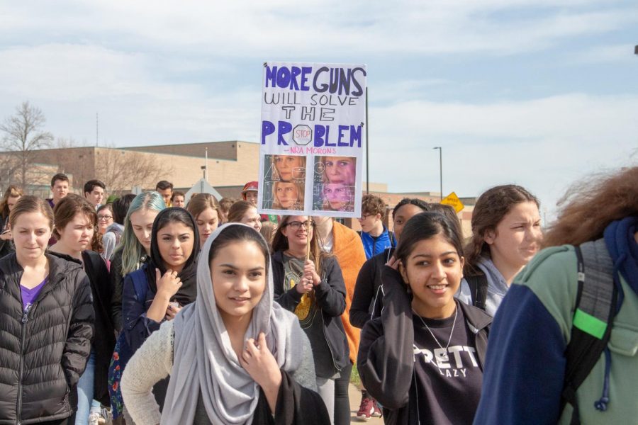Marching+around+the+outside+of+the+school+during+the+National+School+Walkout+against+gun+violence%2C+sophomore+Naomi+Kraemer+holds+up+a+sign.