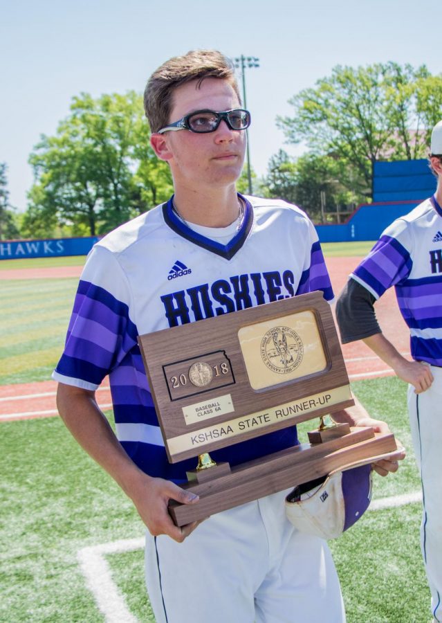 Senior Scott Duensing holds the runner-up trophy after the Huskies matchup with Blue Valley at Hoglund Ballpark May 26. The Tigers defeated the Huskies, 1-0. 