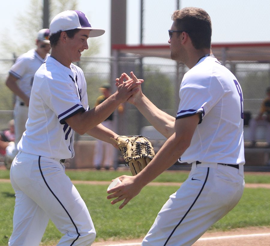 Junior Ryan Freiermuth congratulates junior pitcher Tyler McQuinn after catching a line drive against Shawnee Mission South at the DAC May 5. The Huskies lost to the Raiders 3-4 in eight innings.