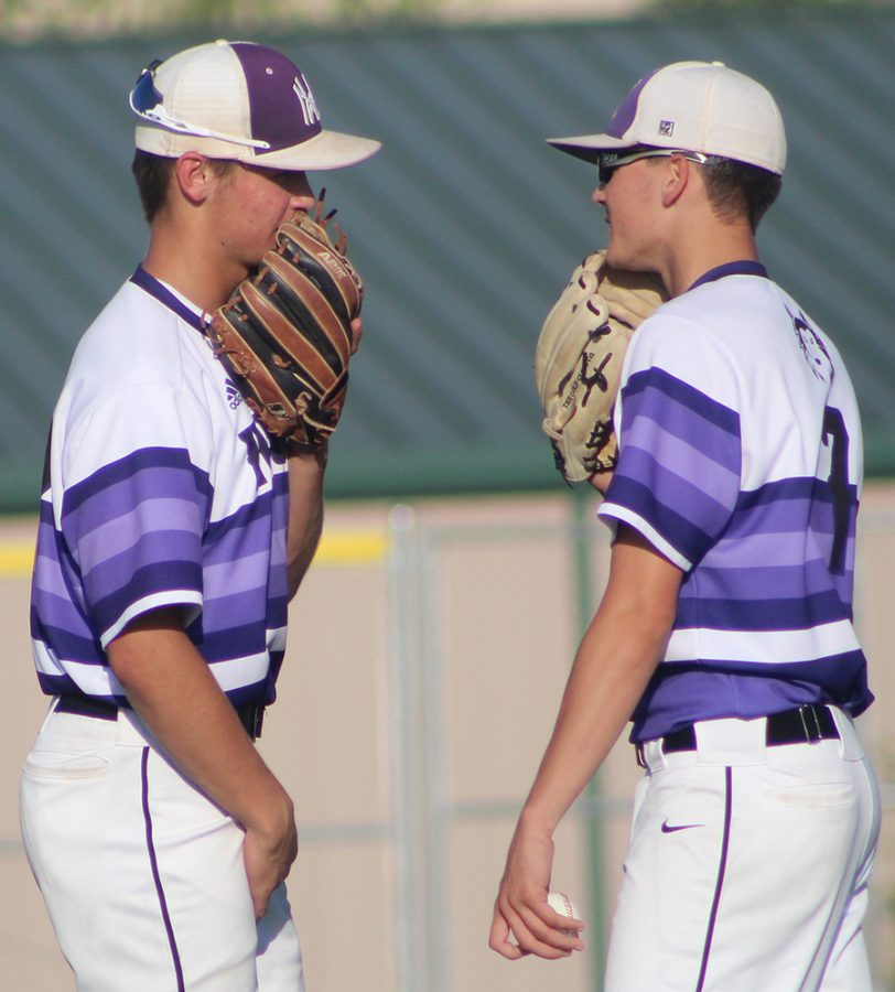 Senior pitcher Scott Duensing and sophomore shortstop Ryan Callahan talk before Duensing faces an Olathe North batter against Olathe North High School at the ODAC May 10. The Huskies defeated the Eagles 14-1 in six innings.