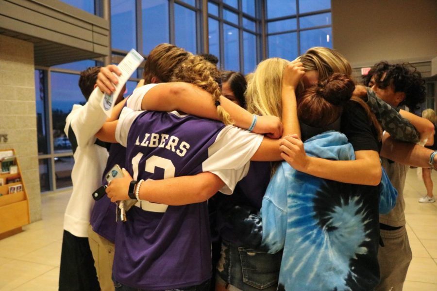 Friends of John Albers hug each other following the first JOCO United meeting on Aug. 29.