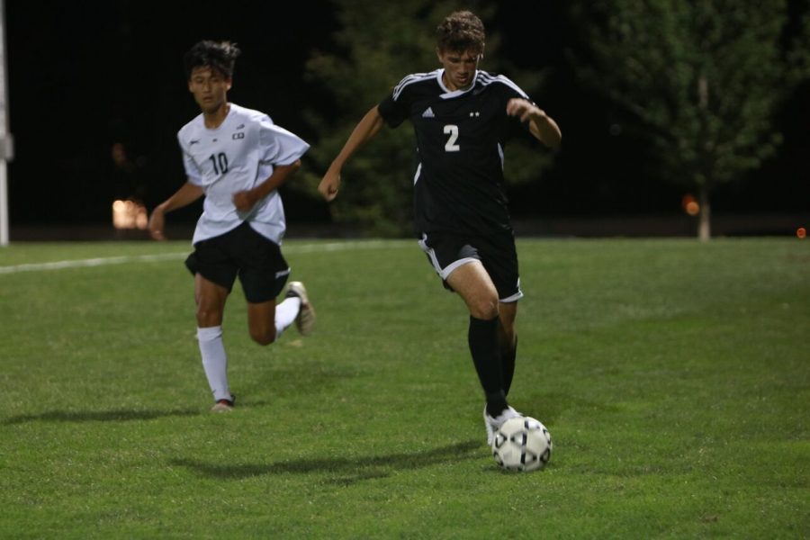 Junior John Fischbach dribbles up the field in game agains Blue Valley West Sept. 20 at the DAC.