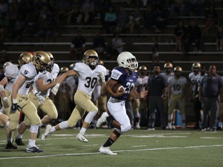 Junior running back Avion Tucker (26) runs for a 49 yard touchdown in the game against St. Thomas Aquinas on Thursday Sept. 13 at the DAC. The Huskies were defeated by the Saints, 49-14.