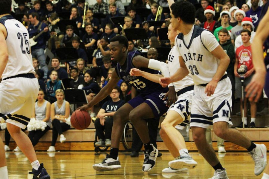 Junior Markell Hood dribbles the ball down the court in the rivalry game against the Mustangs. The Huskies defeated the Mustangs 58-52, Dec. 14. 