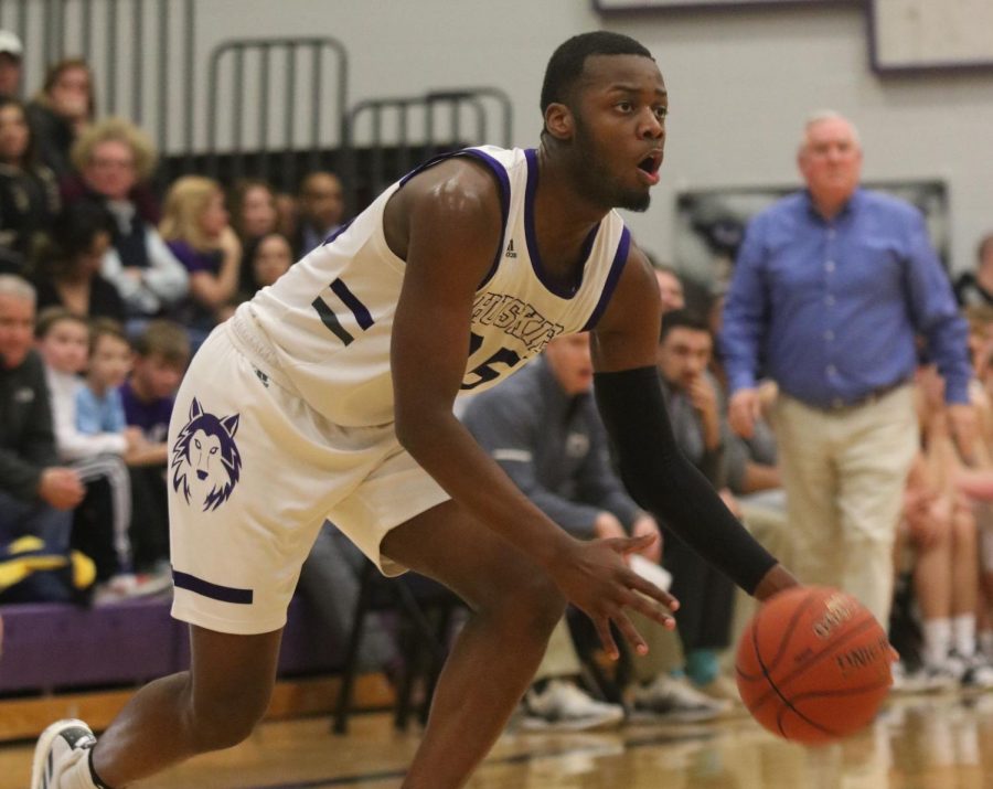 Senior move in Markell Hood dribbles the ball in the game against Blue Valley on senior night on Feb. 14 at BVNW. The win improved the Huskies record to 17-2.