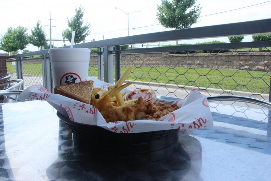 The three piece chicken tender meal from Slim Chickens sits on a table outside. 