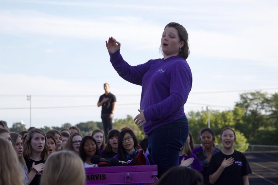 Choir+director+Beth+Richey-Sullivan+conducts+the+choir+students+during+the+National+Anthem+before+the+Husky+Night+parade+in+August+of+2019.+