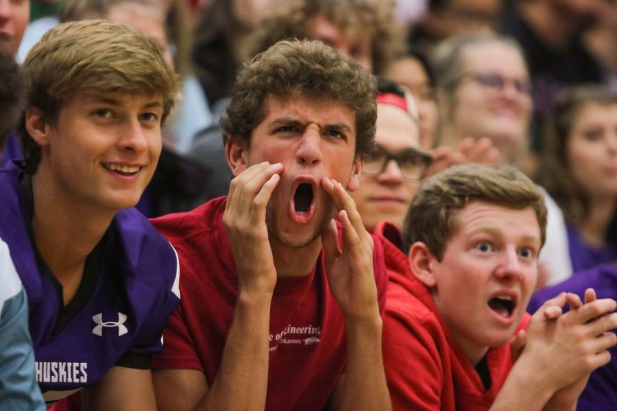 From left-right, Drew Coble, John Fischbach and Taylor Carter cheer from the senior section after a performance during the pep assembly. 