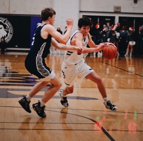 Junior Jack Chapman drives past a defender in the boys varsity basketball game on Dec. 20.
