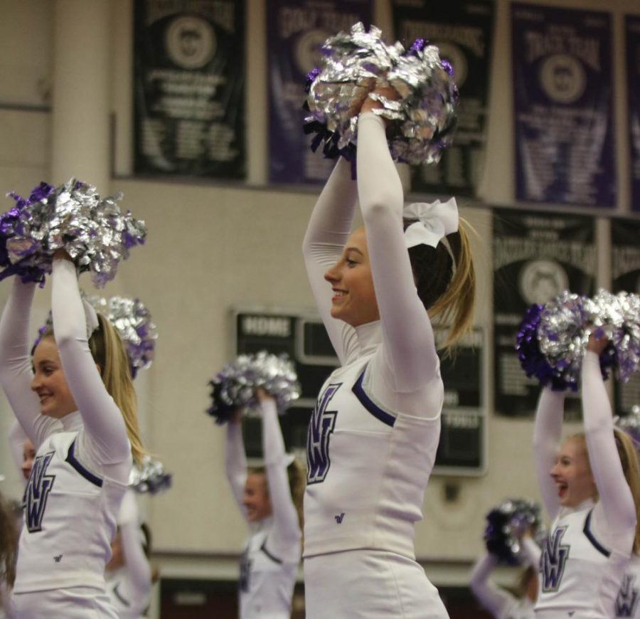 Sophomore Lindsey Noon claps over her head during the cheerleading performance, on Dec. 2. 