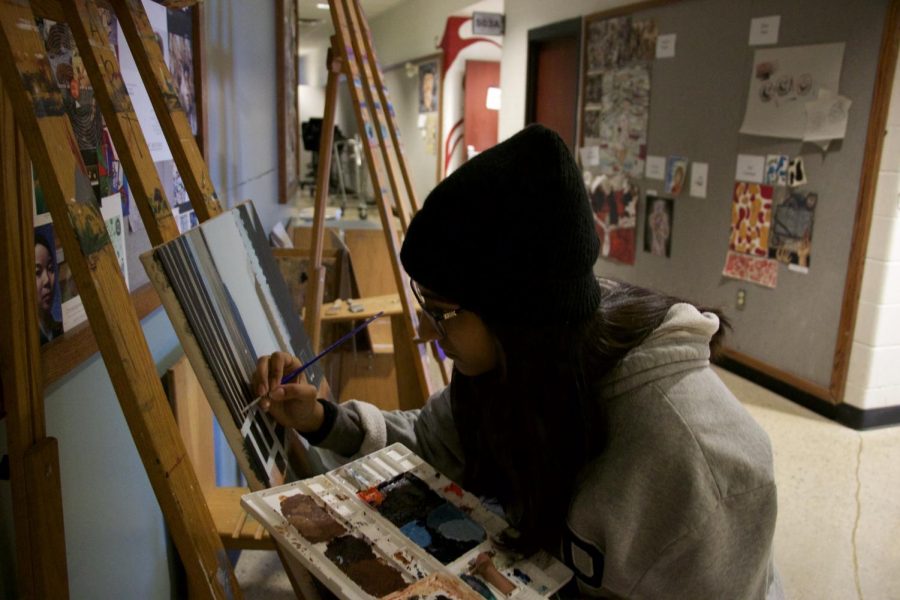 Junior Alina Mahli paints a picture in the art hallway, on Nov. 16. 