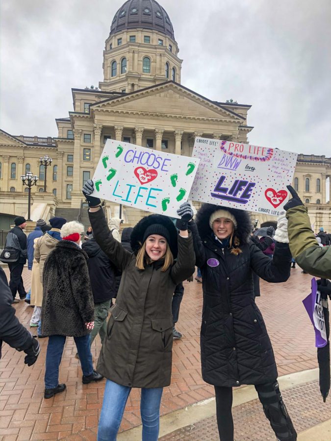 Laura Benteman (Left) and Emily Yohon (Right) hold up signs at the Rally for Life event in Topeka Kan. Jan. 22. 