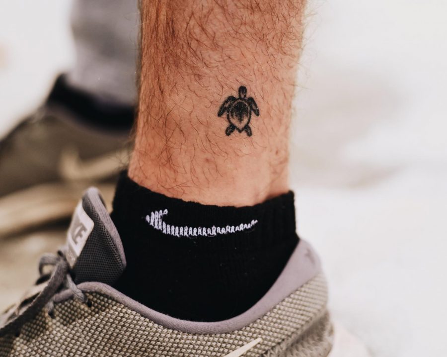 Senior Maclain Michael shows a turtle tattoo on his ankle. “My favorite part about my tattoo
is how small and simple it is. I got the tattoo because I love turtles and it reminds me how dope
nature is,” Michael said. 