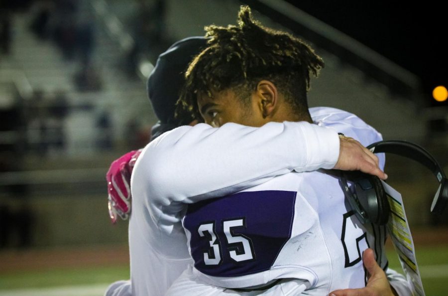 Freshman Grant Stubblefield hugs coach Clint Rider after the playoff loss to Shawnee Mission Northwest, Nov. 1.