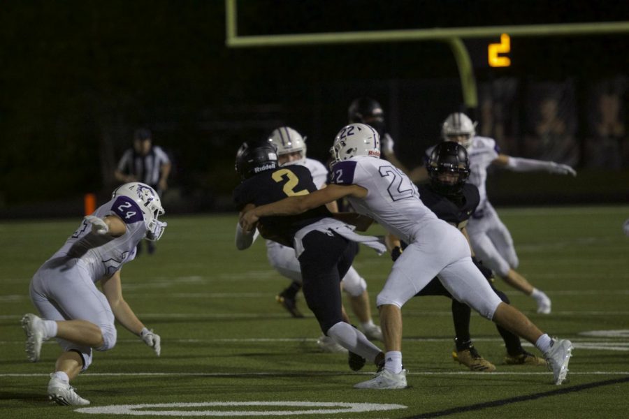Junior Drew Kaufman tackles the Blue Valley quarterback.