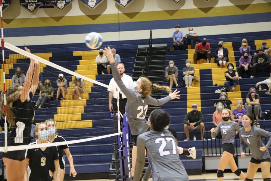 Junior Audrey Malis (23) rises to hit the ball in the girls varsity volleyball game against Blue Valley, Sept. 15.