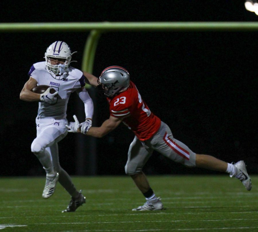 Junior Nick Cusick runs the ball in the varsity football game against Blue Valley West, Oct. 23. (Photo by Grace Davis)