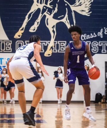 Senior point guard Alston Mason dribbles the ball in the varsity basketball game against Blue Valley North.