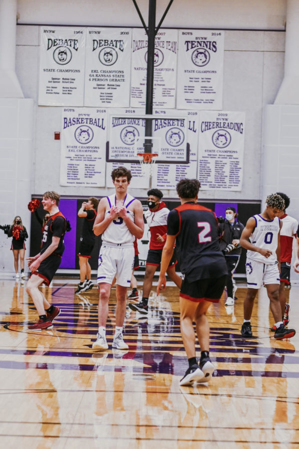 Senior Jack Chapman (3) and sophomore Grant Stubblefield (0) walk off the court as Lions players celebrate their win.