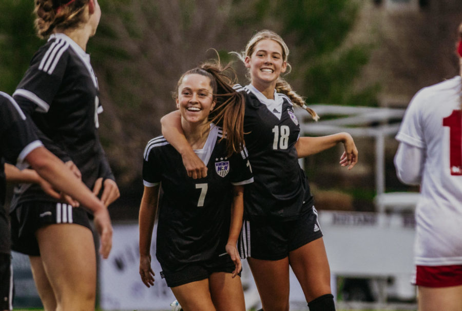 Sophomore Reagan Priest (7) celebrates scoring a goal with senior Isabel Schelhammer (18). Priest finished the game with a hat trick.