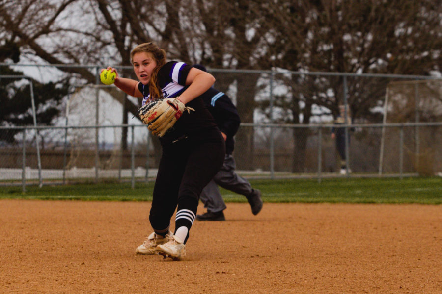 Junior Sammie Carey throws the ball to first base in the varsity softball game against St. Thomas Aquinas.
