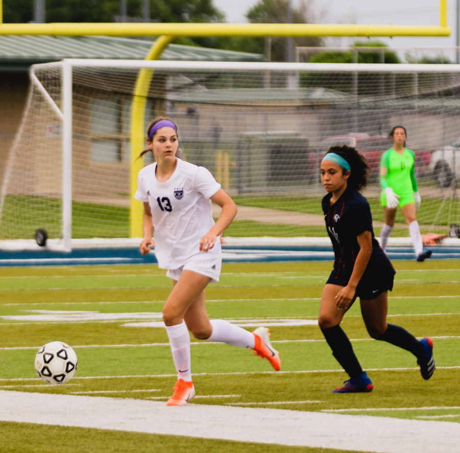 Freshman Isabelle De Buyl (13) looks for a teammate to pass to during the girls varsity soccer regional championship game.