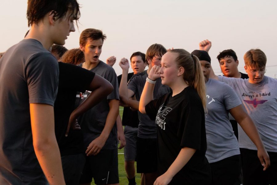 Freshman Caitlyn Kingler breaks the huddle with her teammates during a football practice.