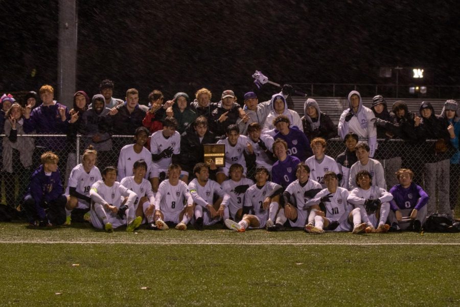 The varsity soccer team poses for a picture with members of the student section after winning the regional championship, Oct. 28.