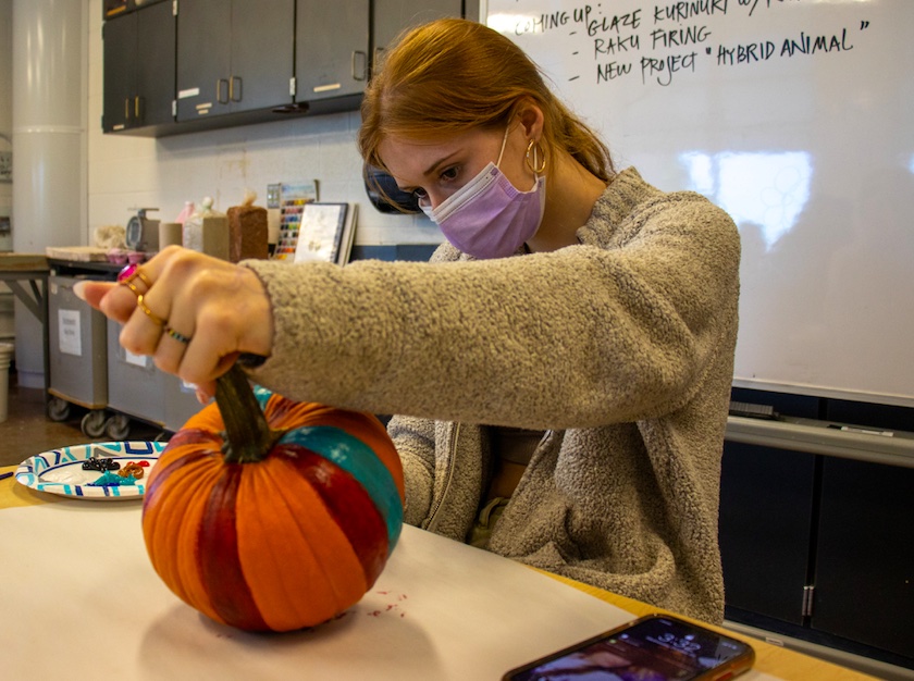 Senior Kendra Colerick, as part of the National Art Honor Society, paints a pumpkin with fellow members of the society, Oct. 20. 