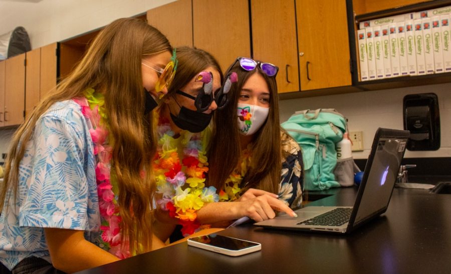 Working in their science class, sophomores wear hawaiian clothing to dress for the theme of the day, Sept. 28.