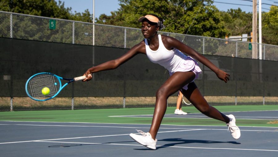 Freshman tennis player Maryam Wambi forehands the ball during a match against Shawnee Mission South, Sept. 8.