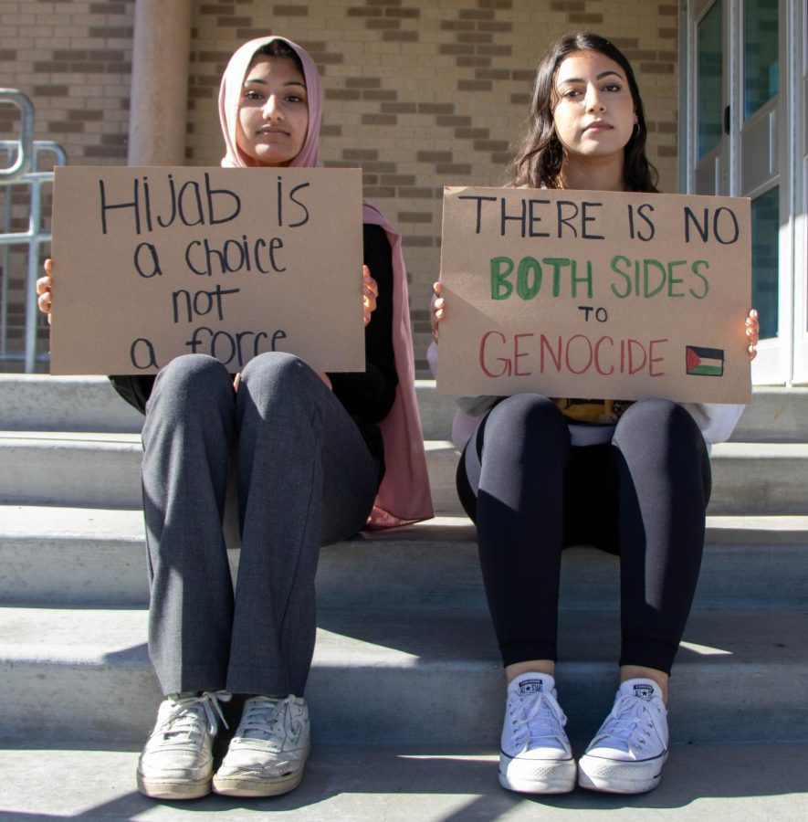 Sophomore Safa Qureshi and senior Hiba Issawi hold signs to represent protests in Middle Eastern countries and their own beliefs.