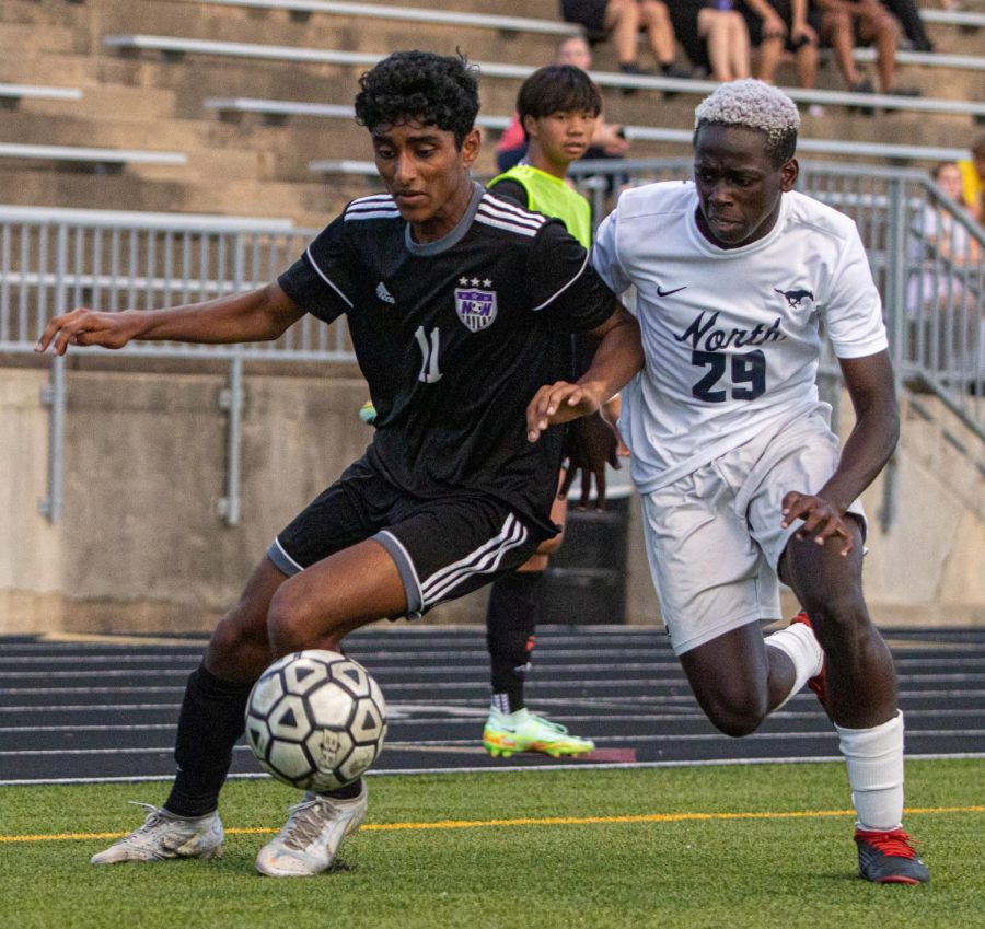 Senior soccer player Tanay Dunthuluri dribbles the ball in a match against Blue Valley North, Aug. 26.