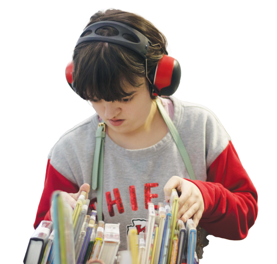 Senior Jaden Hill sorts books at her job at the Johnson County Library.