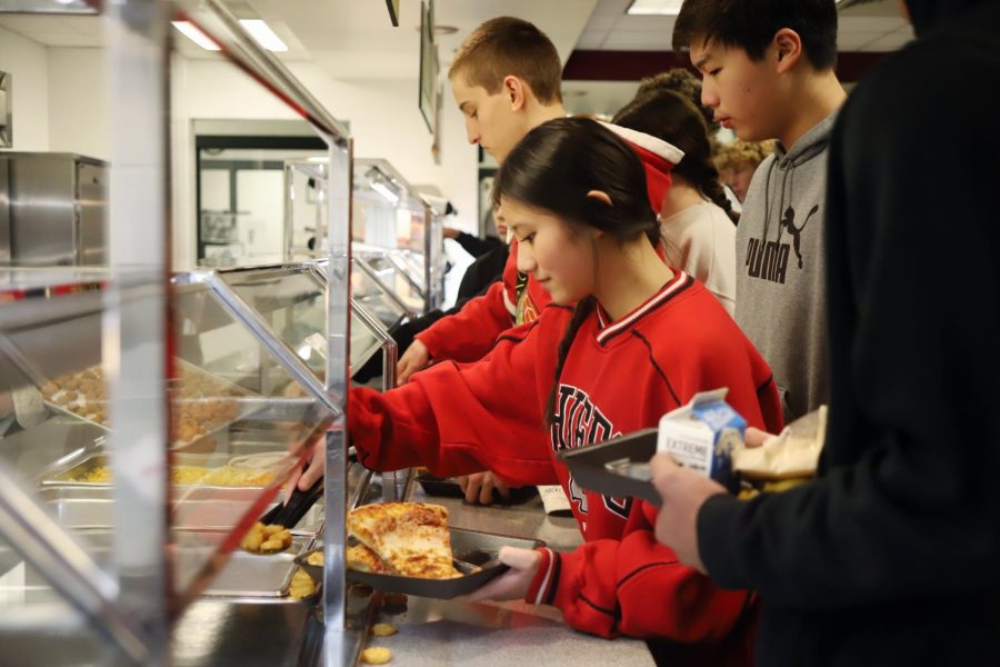 Students wait in line to get lunch in the crowded cafeteria. 