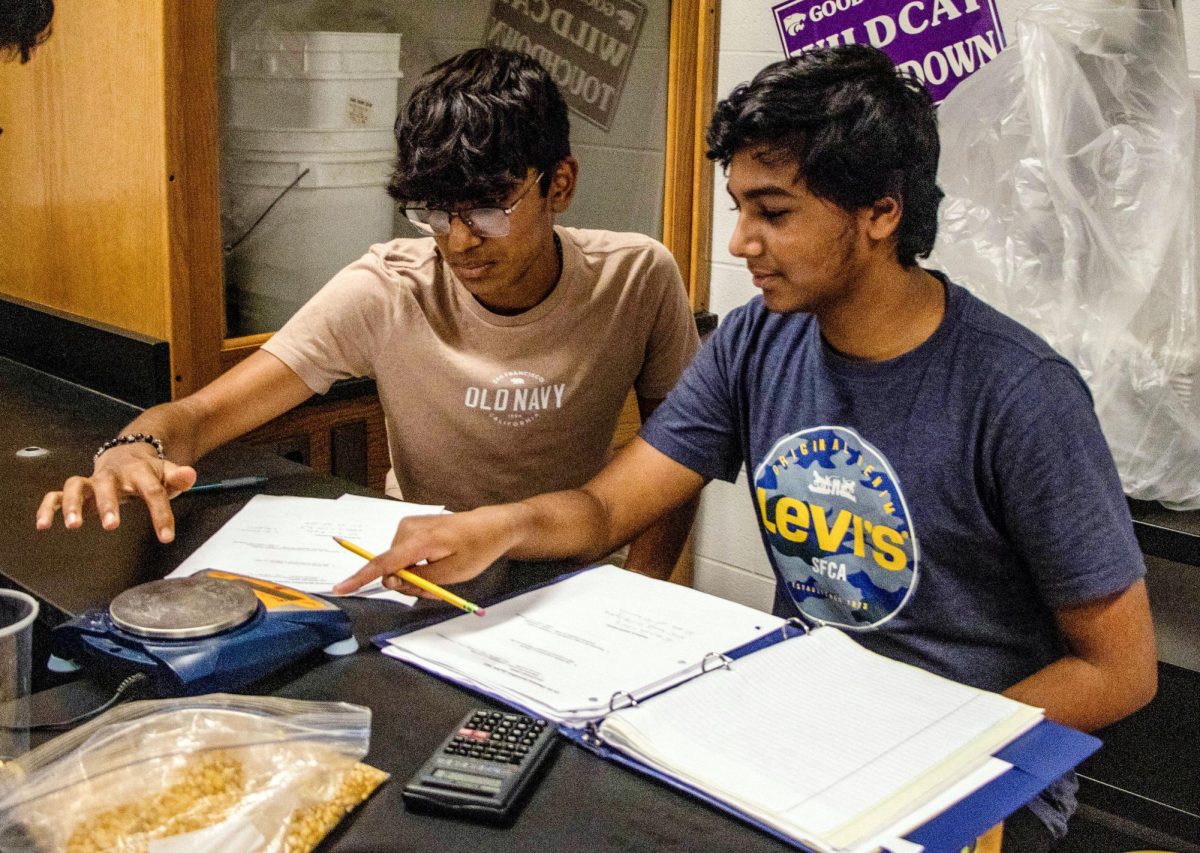 During his 7th hour honors chemistry class, sophomore Aadit Gupta [right] learns how to count in large amounts by measuring mass with his classmate Dhirav Kamble [left], Sept. 15. “Taking an all honors and AP schedule makes it hard to keep up with work and takes up a lot of family time and time away from friends,” Gupta said. “If you handle it responsibly though, it will definitely have a positive impact.”